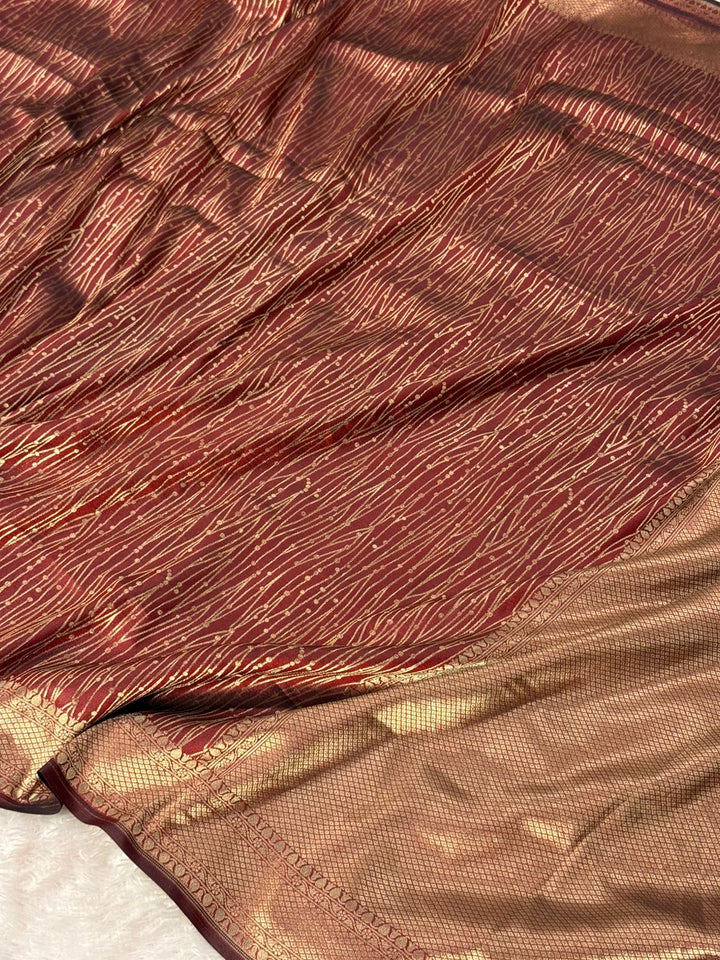 Close-up of textured maroon Pure Katan Silk Golden Zari fabric with a subtle pattern